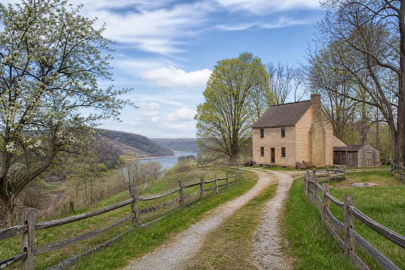 An interpretive rural lane approaching a modest early nineteenth-century farmhouse