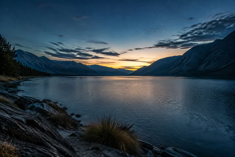 A quiet mountain lake beneath the first light of dawn
