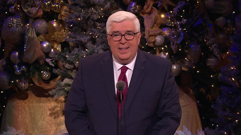José A. Teixeira speaking at a Christmas-decorated lectern.